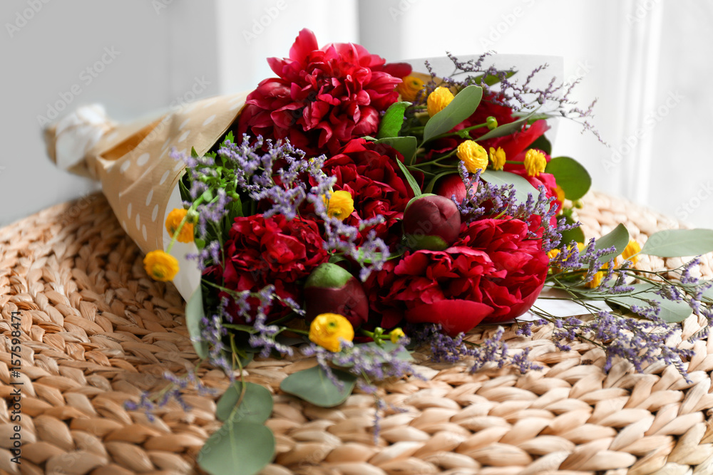 Bouquet with beautiful peonies on ottoman, closeup