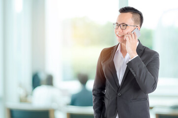 Wall Mural - Handsome asian businessman using smart phone in office