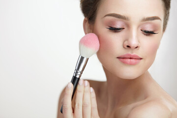 Wall Mural - facial beauty cosmetics. sexy woman applying blush with brush