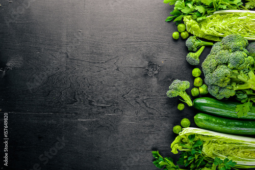 Stampa su Tela Collection of fresh green vegetables placed on black stone