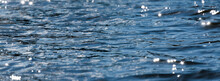 Water With Bokeh Background. Water Surface With Waves Glittering In The Sun. Banner For Website