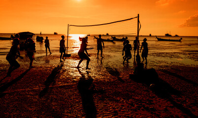 silhouette Group of friends playing beach volley - group of people having fun on the beach