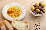 Fototapeta Kuchnia - fresh bread, cut into slices with olives and olive oil with balsamic vinegar in a bowl