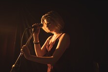 Female Singer Holding Microphone In Nightclub