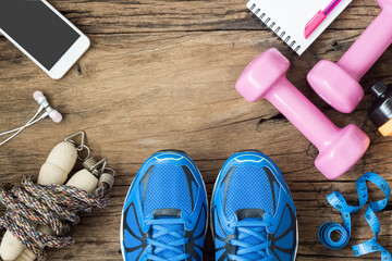 Poster - Fitness, healthy and active lifestyles Concept, dumbbells, sport shoes, bottle of waters, smartphone, jump rope and apples on wood background. copy space, top view