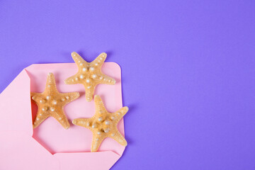 Pink envelope with three starfishes on colored purple background