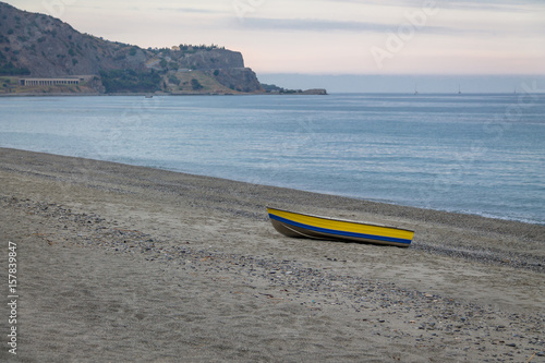 Fotografie, Obraz Blue and Yellow boat in a Mediterranean beach of Ionian Sea - Bova Marina, Calab
