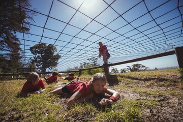 Wall Mural - kids crawling under the net during obstacle course training