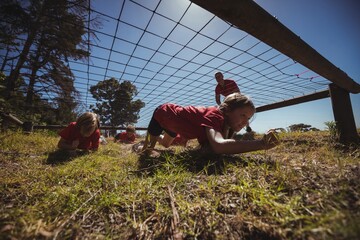 Wall Mural - kids crawling under the net during obstacle course training
