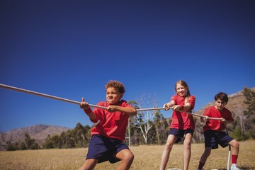 Wall Mural - kids playing tug of war during obstacle course training