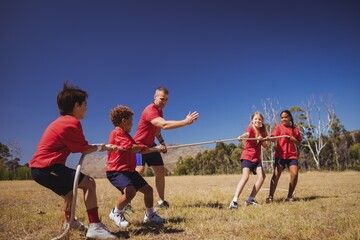 Wall Mural - kids playing tug of war during obstacle course training