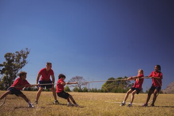 Wall Mural - kids playing tug of war during obstacle course training