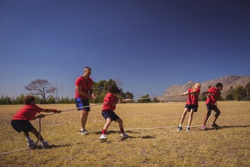 Wall Mural - kids playing tug of war during obstacle course training