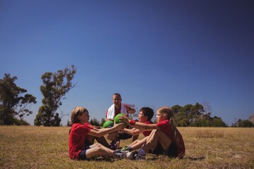 Wall Mural - trainer instructing kids while exercising in the boot camp