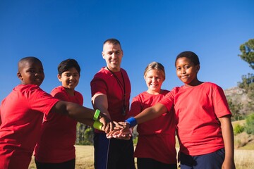 Wall Mural - trainer and kids forming hand stack in the boot camp