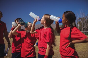 Wall Mural - trainer and kids drinking water in the boot camp