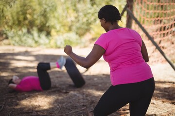 Wall Mural - trainer assisting woman while exercising during obstacle course