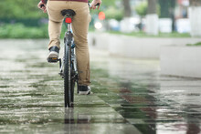 Man On A Bicycle At Asphalt Road In Summer. Bike In The Park Moving Through Puddle On Rainy Day