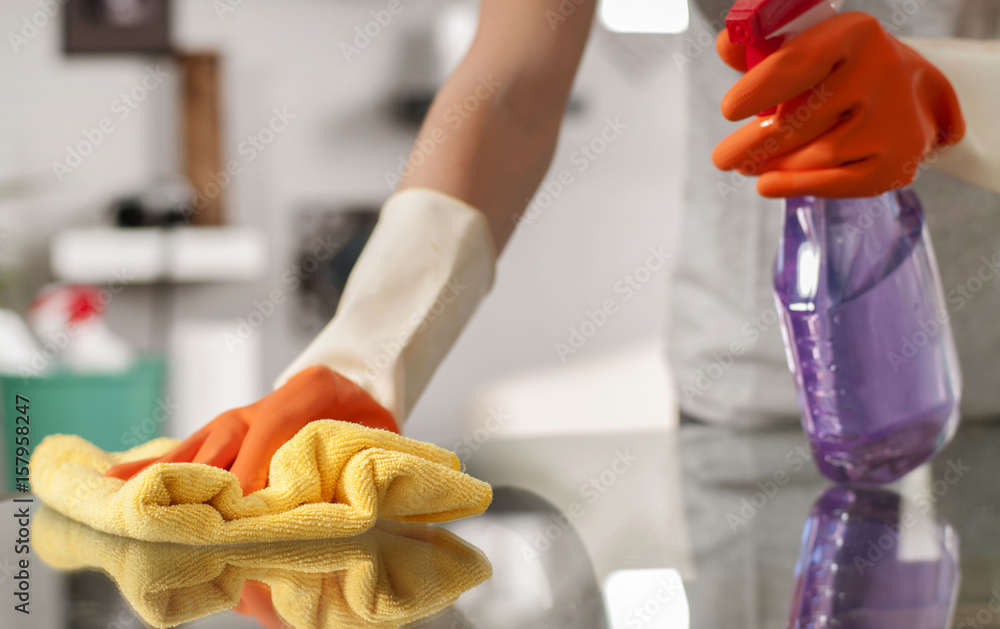Woman in gloves cleaning table with spray. - obrazy, fototapety, plakaty 