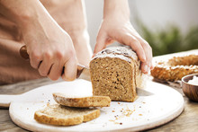 Female Hands Cutting Whole Wheat Bread