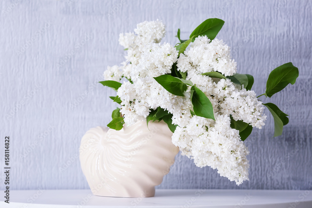 Beautiful bouquet of lilac in vase on table