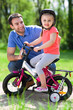 © pikselstock - Girl learning to ride a bicycle with father