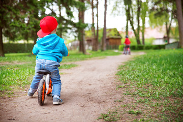 children riding on a bicycles at gravel road in the park in summer