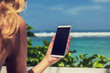 © astrosystem - Girl using cellphone in the coffee shop on a tropical exotic beach.