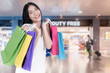 © ake1150 - Beautiful Asian woman with shopping bags in duty free in International Airport before departure. Sale, shopping, tourism and happy people concept