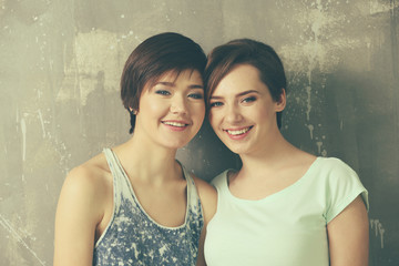 Wall Mural - Young lesbian couple on grunge background