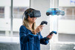 A woman wearing a virtual reality headset looks at a 3D model of a car.