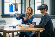 Business colleagues review a mobile phone design concept wearing a virtual reality headset.