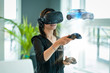 A business woman wearing a virtual reality headset, interacts with a 3d model of a car.