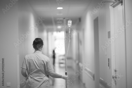 Plakat Pielęgniarka nosi ze statywem roztwór do infuzji w szpitalu.