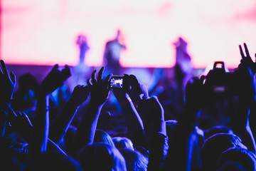 View of rock concert show in big concert hall, with crowd and stage lights, a crowded concert hall with scene lights, rock show performance, with people silhouette