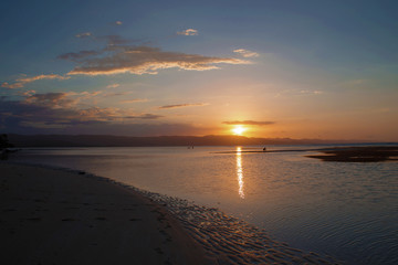 Wall Mural - Orange sunset on the beach. Sun reflection on the sea