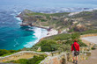 © fabio lamanna - Tourist hiking at Cape Point, looking at view of Cape of Good Hope and Dias Beach, scenic travel destination in South Africa. Table Mountain National Park, Cape Peninsula.