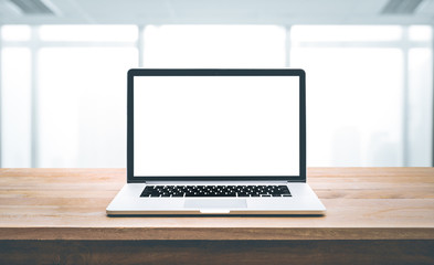 Wall Mural - Modern computer,laptop with blank screen on wood table with office window view background