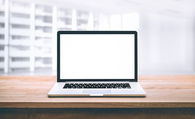 Wall Mural - Modern computer,laptop with blank screen on wood table with office window view background