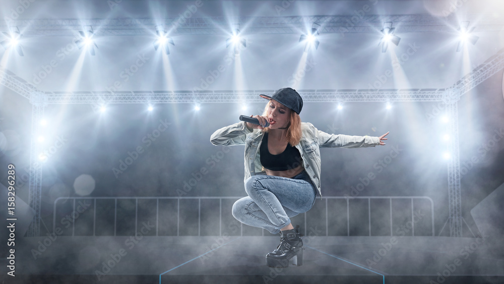 Female singer in casual style performing with lights on background ...