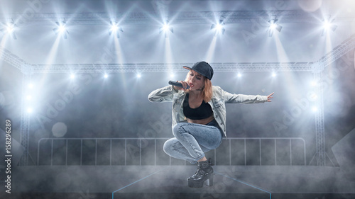 Zdjęcie XXL Żeński piosenkarz w przypadkowego stylu spełnianiu z światłami na tle