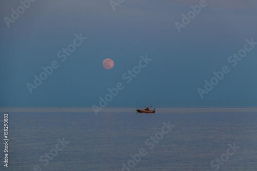 Fotografie, Obraz A boat and a rising moon in a Mediterranean beach of Ionian Sea - Bova Marina, C