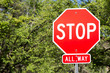Stop sign against green leaves