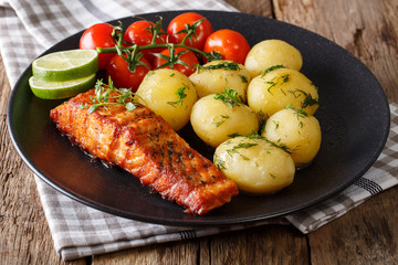 grilled salmon and boiled new potatoes, fresh tomatoes close-up. horizontal