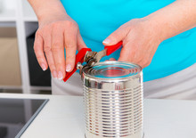 Woman In Blue Shirt Opening A Can In The Kitchen