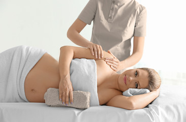 Poster - Young beautiful pregnant woman having massage in spa salon