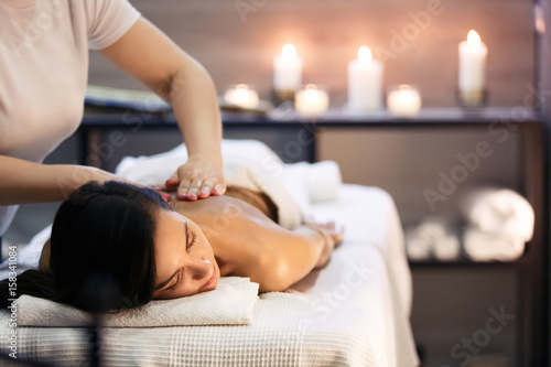 Obraz Dibond Masaż ciała i zabiegi spa w nowoczesnym salonie ze świecami