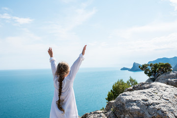 small girl stay on the top of mountain, looking on the beautiful view blue sea and mountains. summer