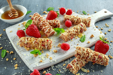 Wall Mural - Granola bar with strawberries, raspberry honey and white chocolate on cutting board