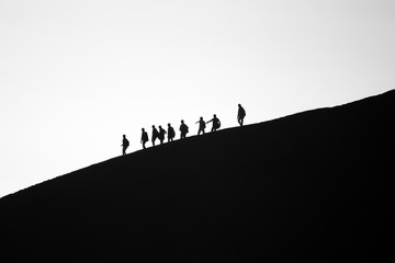 A group of friends descending Mt. Bromo in morning mist. Mt. Bromo is one of the most visited tourist attractions in East Java, Indonesia.